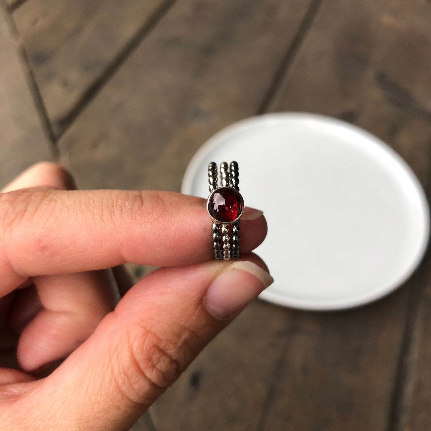 Large Garnet Silver Stacking Ring sandwiched between two black silver stackers rings - Trisha Flanagan