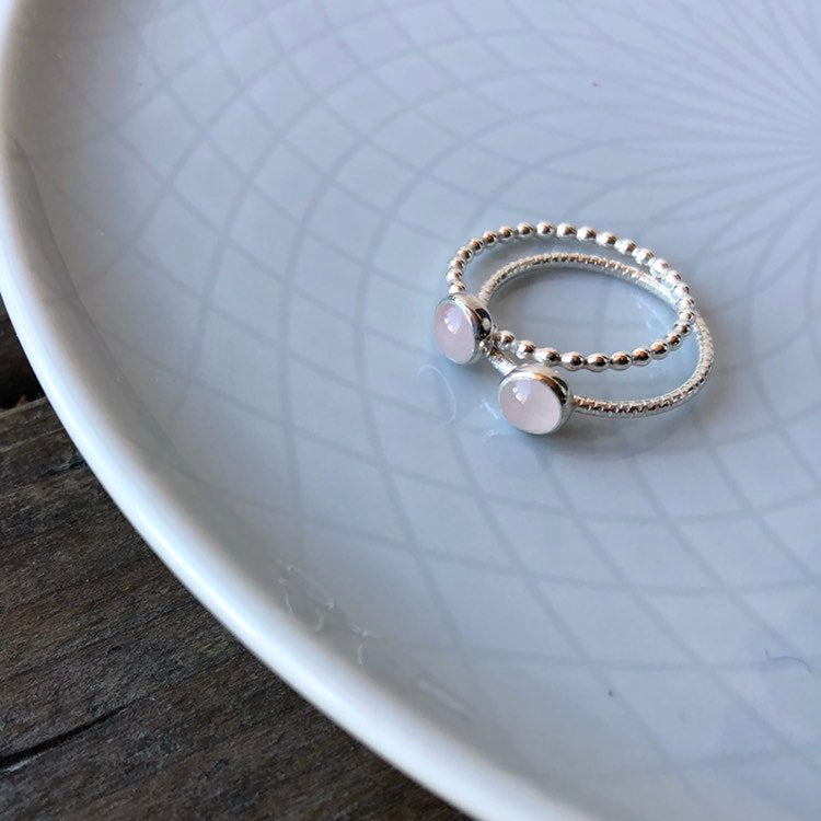 Woman holding rings comparing textured and beaded Rose Quartz Rings - Trisha Flanagan