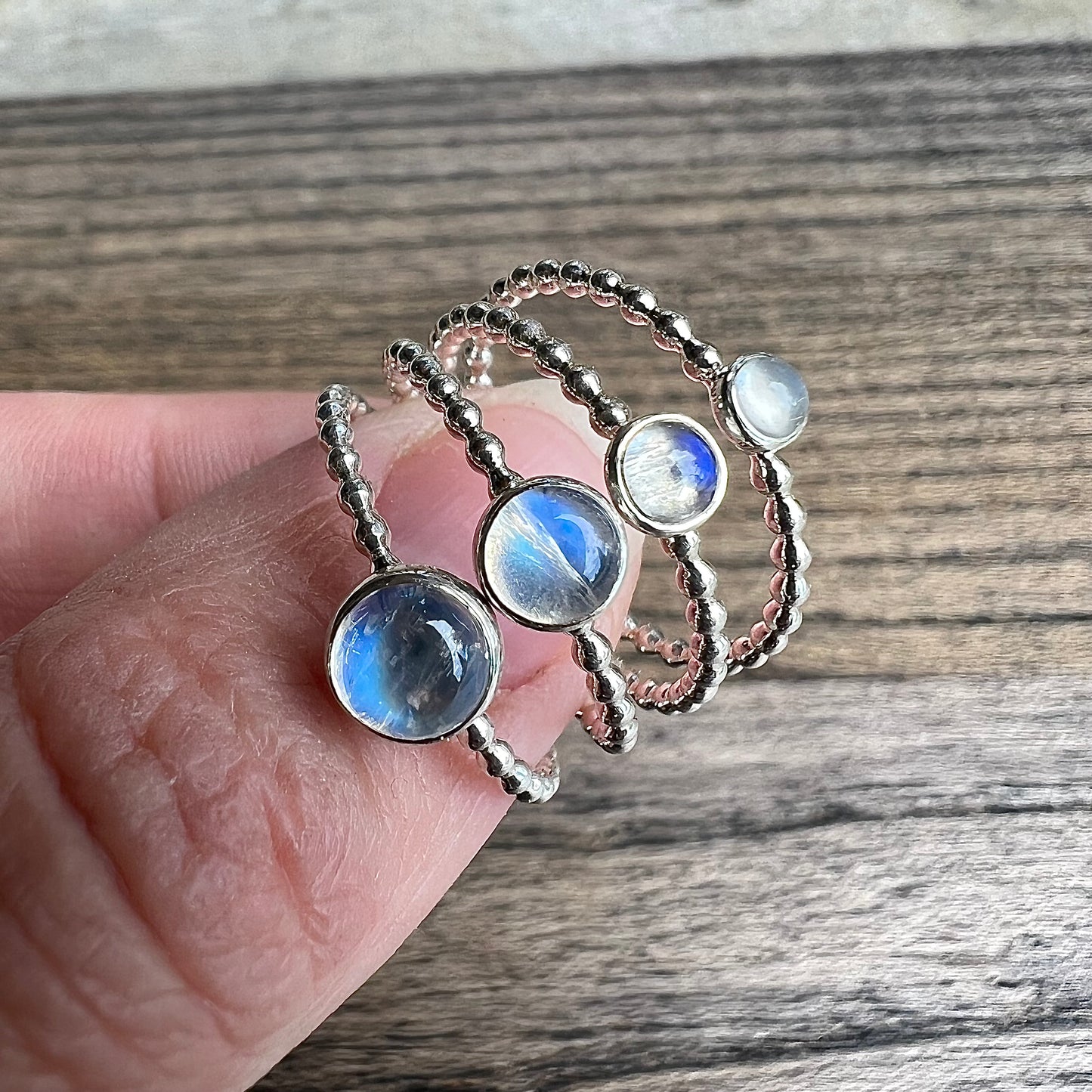 Woman holding different sized Rainbow Moonstone Silver Rings - Trisha Flanagan