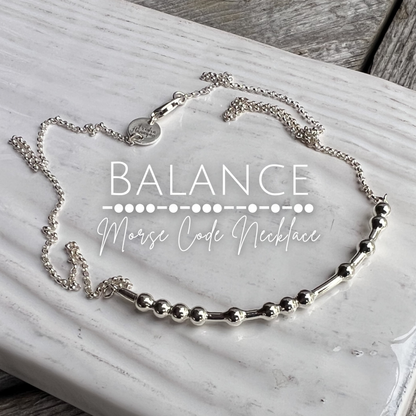 Silver 'Balance Morse Code Necklace' on a marble surface