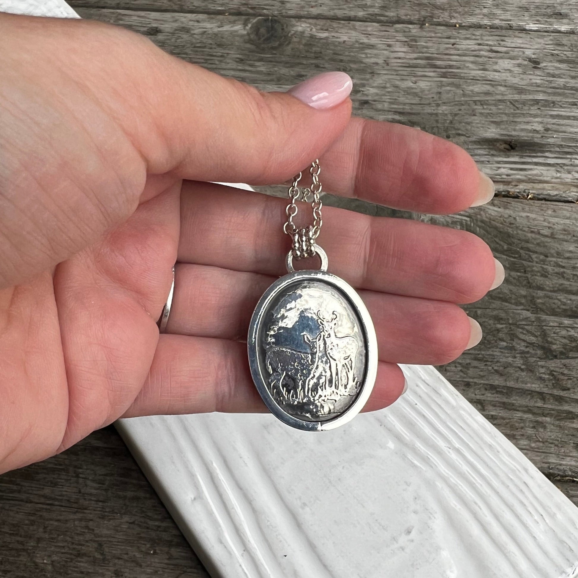 woman holding the Kyanite and Deer Statement Pendant back view