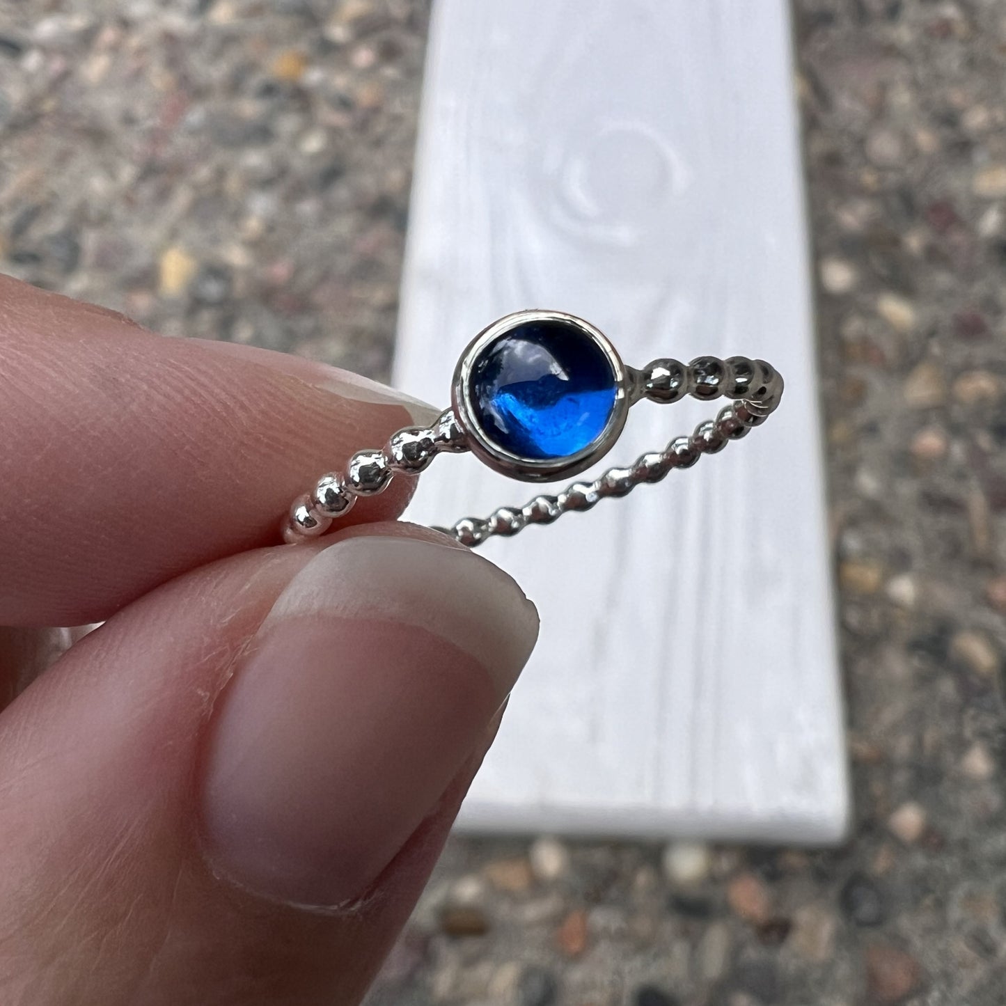 Holding a 5mm Medium Lab Sapphire Ring