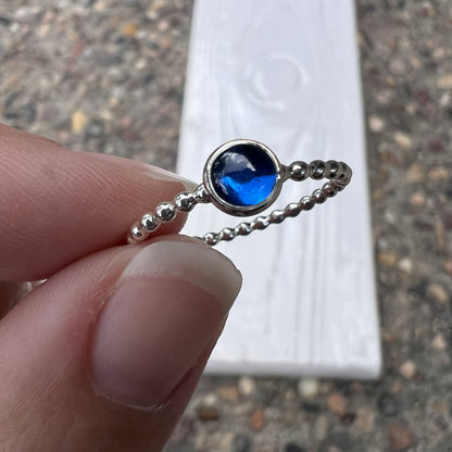 Holding a 5mm Medium Lab Sapphire Ring