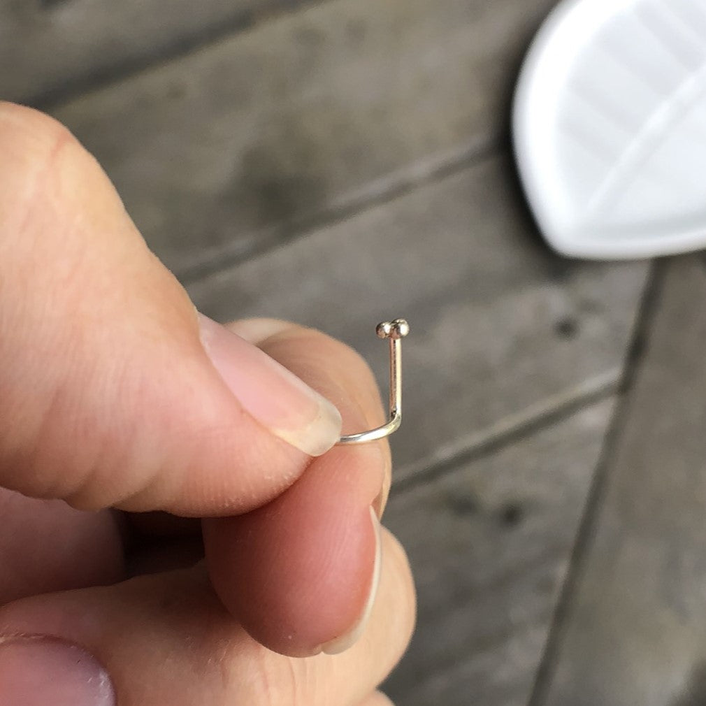 holding a small triangle nose stud side view