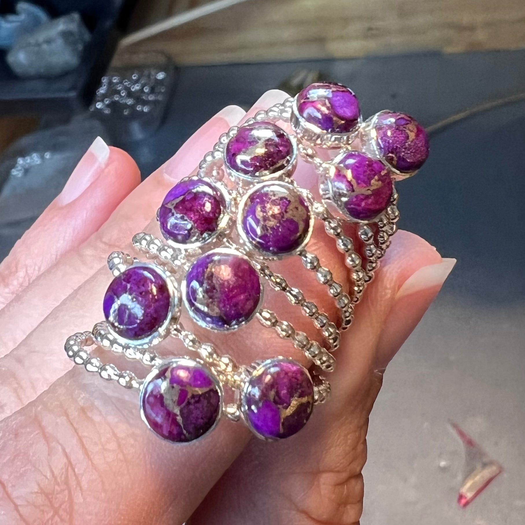 Holding several Purple Copper Turquoise Rings