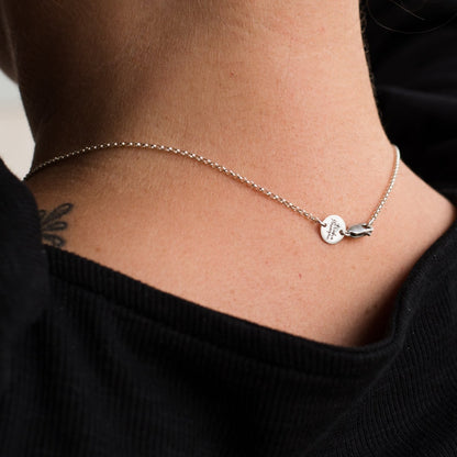 Back of a Womens neck showing the clasp and logo tag of a silver necklace