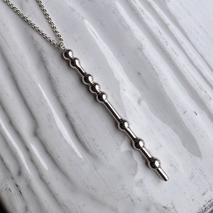 Silver necklace with a unique design on a marble surface