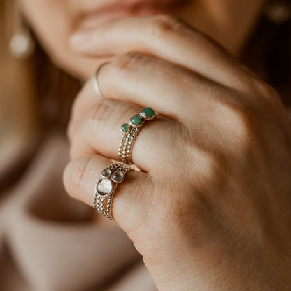 Woman wearing different size Emerald Rings and Different size moonstone rings - Trisha Flanagan