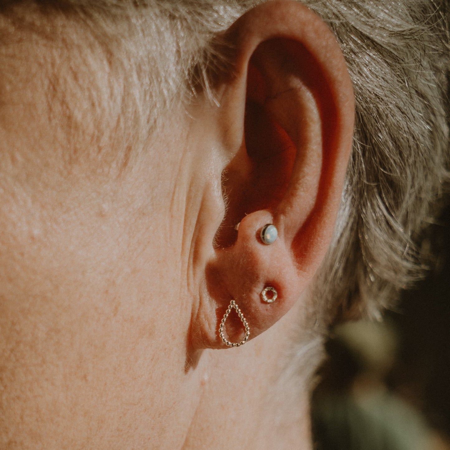 Woman wearing a Micro Textured Circle Studs Earring and a Teardrop Earring - Trisha Flanagan
