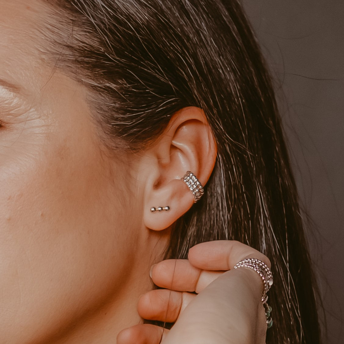 Woman wearing three ear cuffs with earrings