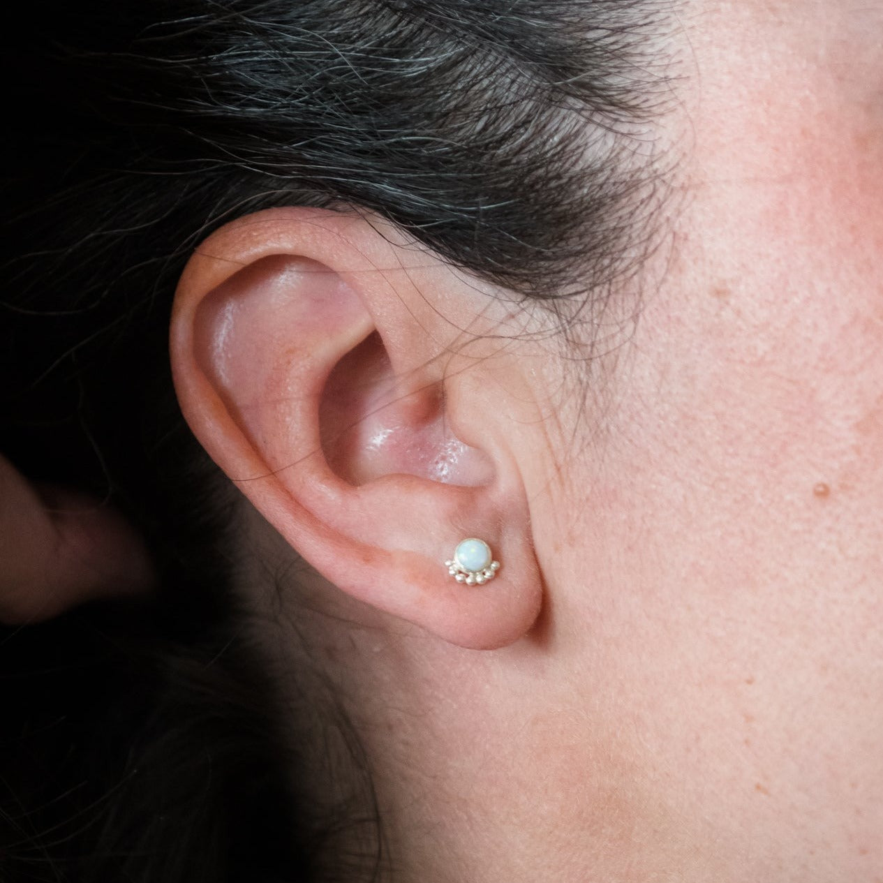 Woman wearing a gemstone eyelash stud earring close up - Trisha Flanagan