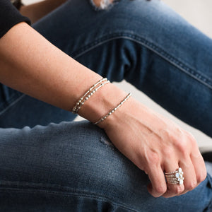 Woman wearing three morse code bracelets
