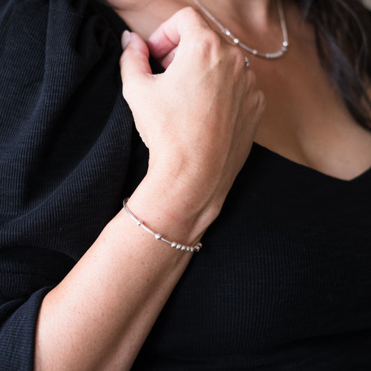 Woman wearing a MAMA BEAR Morse Code Bracelet