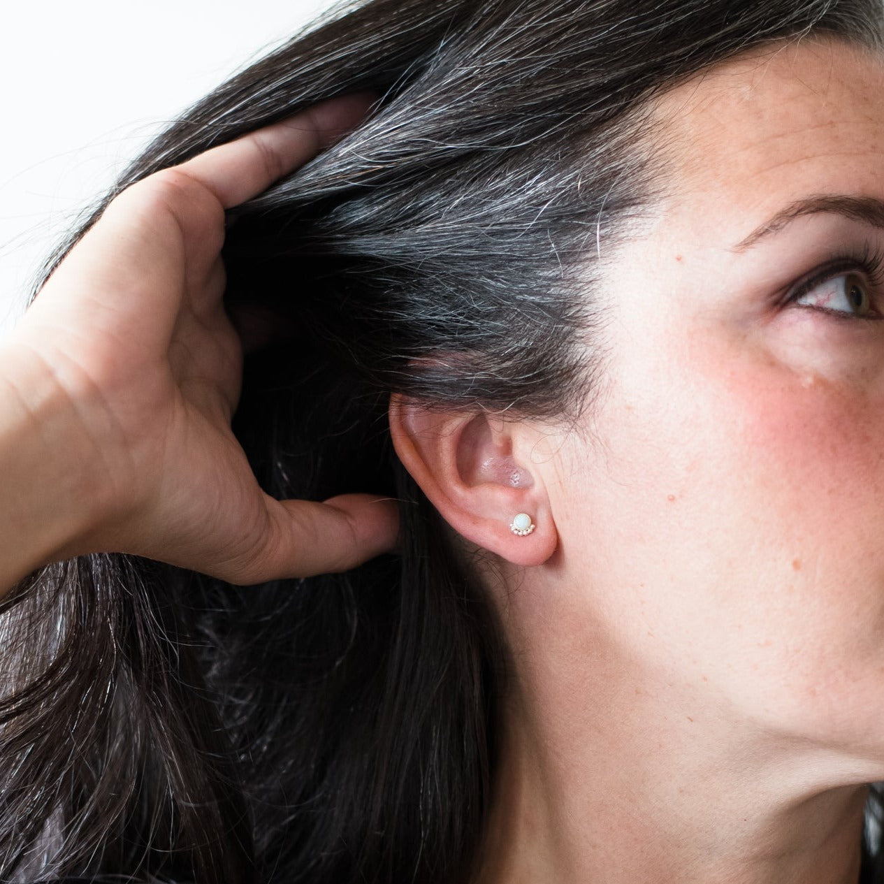 Woman wearing a gemstone eyelash stud earring - Trisha Flanagan