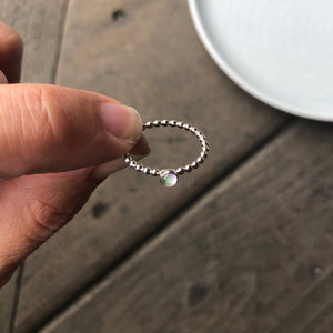Woman holding a Mini White Manmade Simulated Opal Stacking Ring - Trisha Flanagan