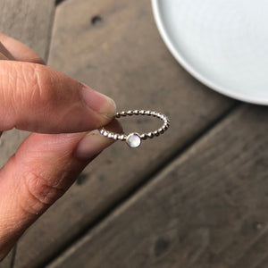 Woman holding a Mini White Manmade Simulated Opal Stacking Ring - Trisha Flanagan